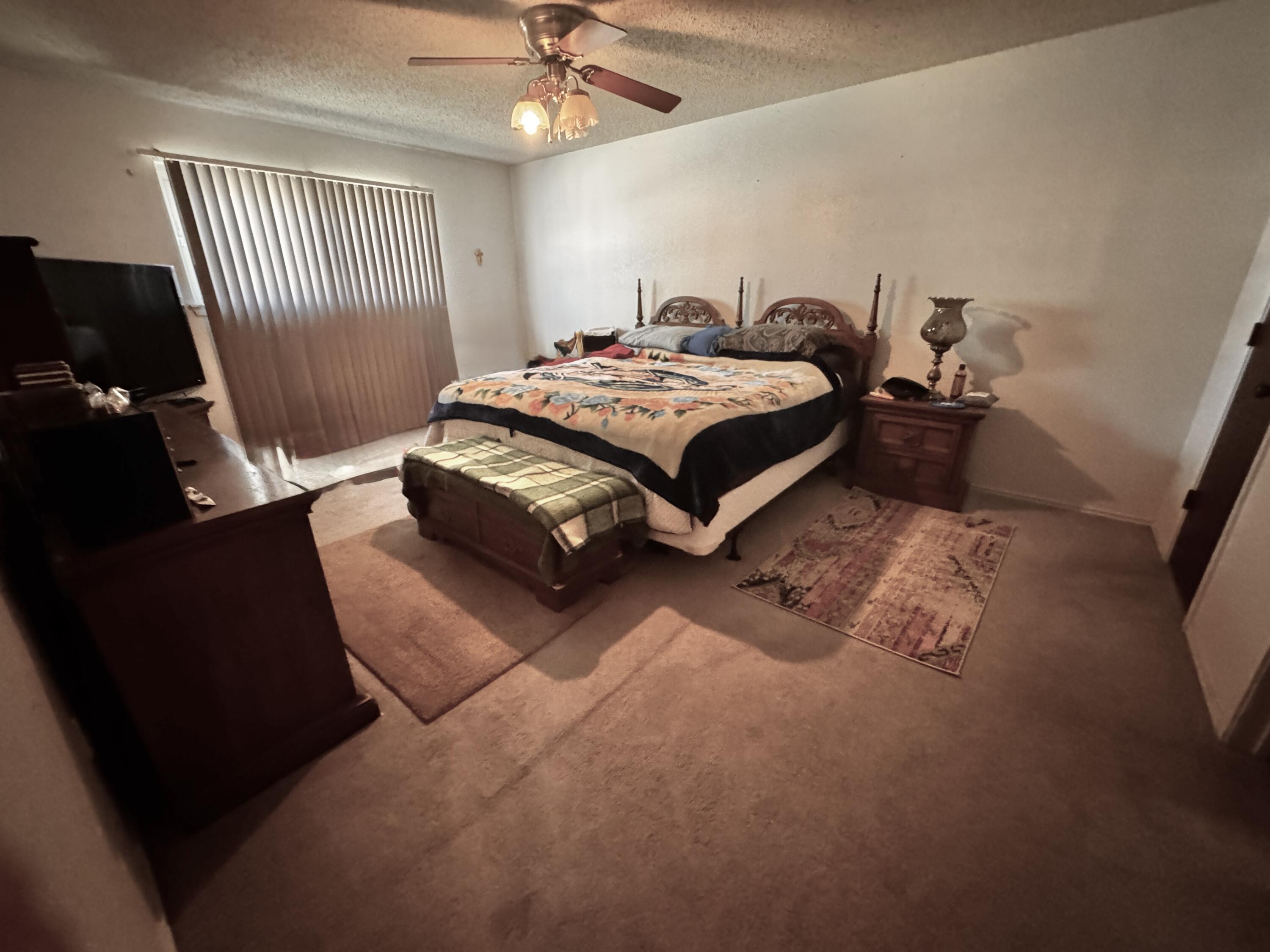 3902 Sides Street Plainview, TX 79072 - Photo 12 of 26 a bedroom with a bed and a chandelier