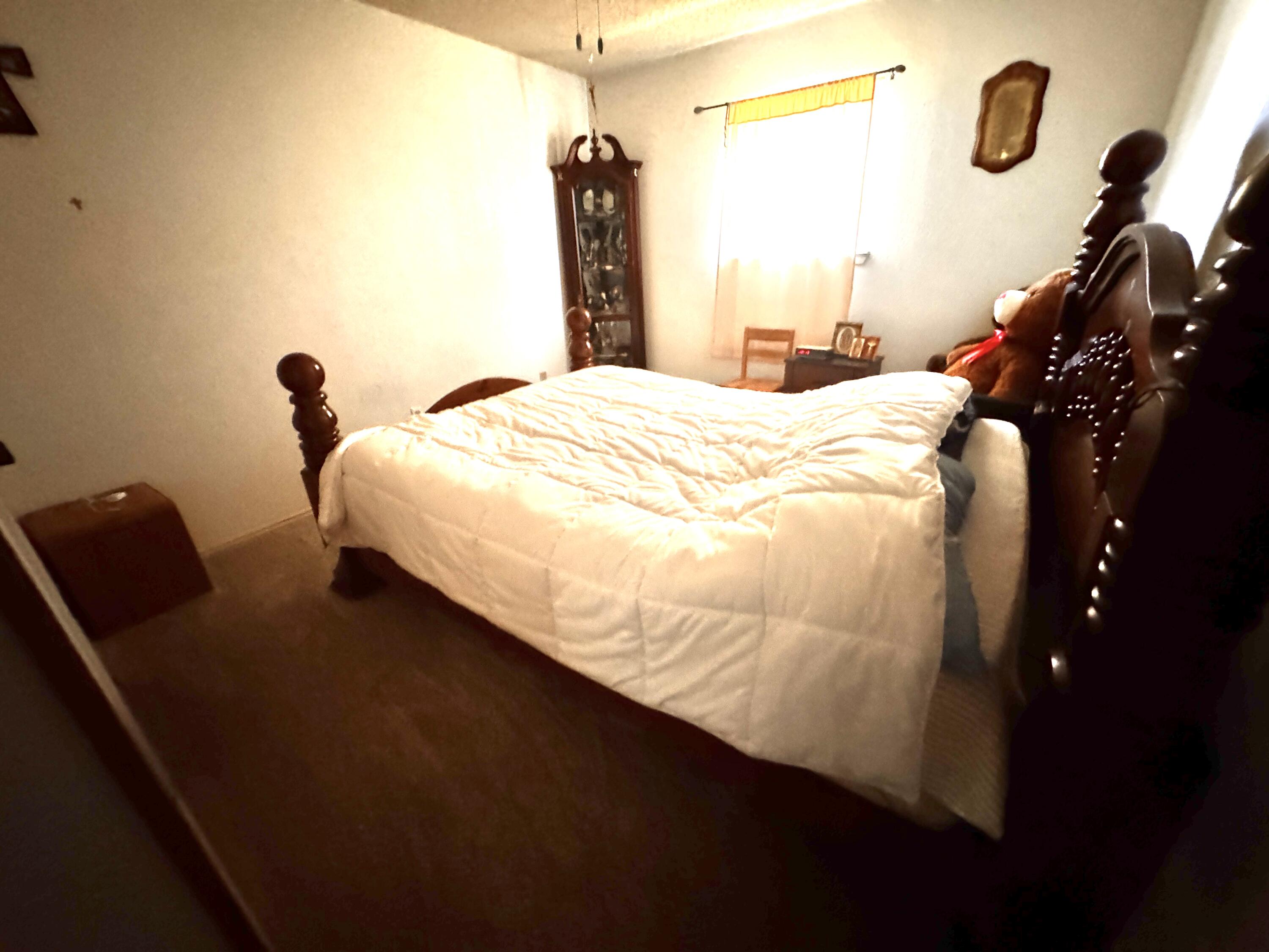 3902 Sides Street Plainview, TX 79072 - Photo 15 of 26 a bedroom with a bed and a chandelier