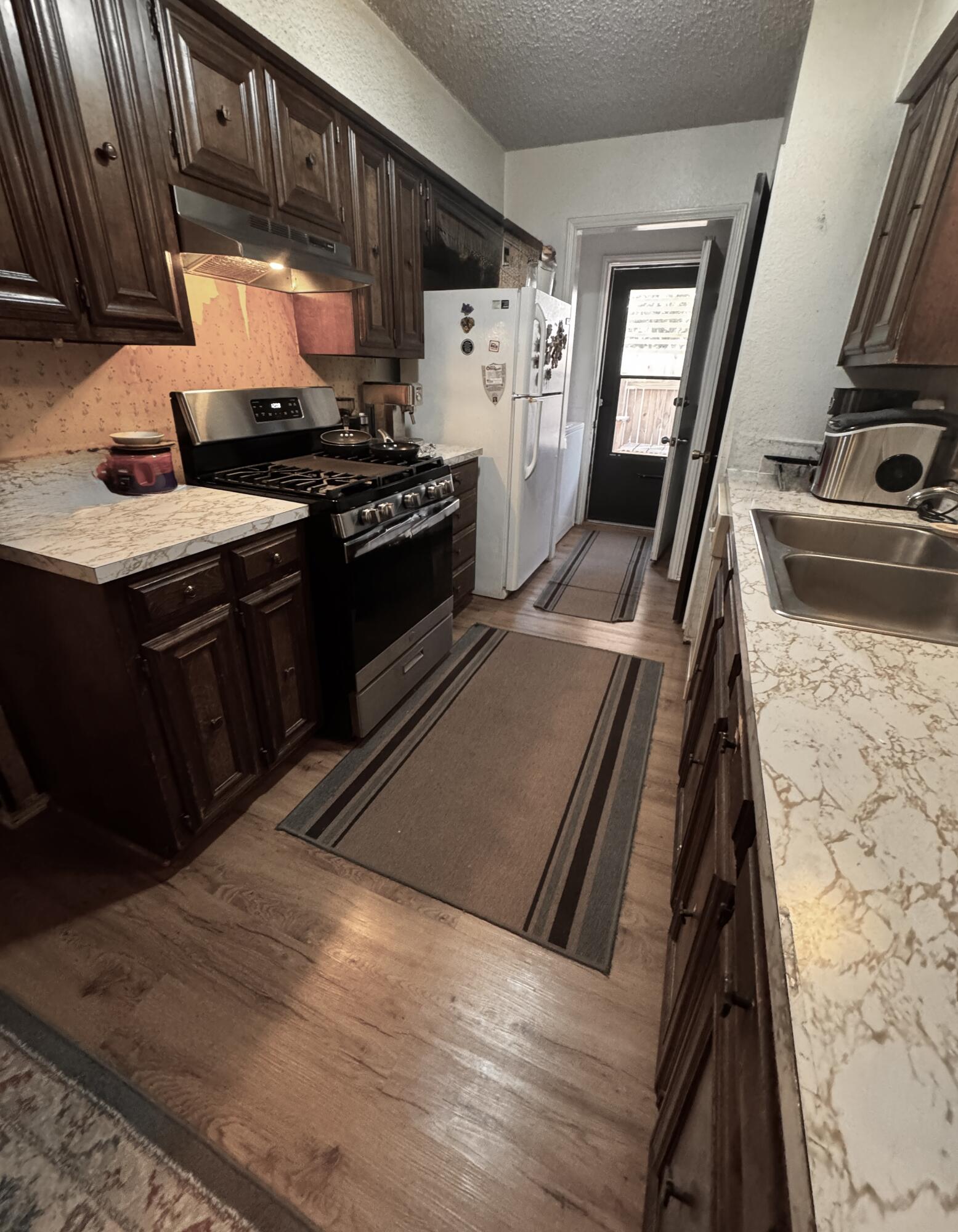 3902 Sides Street Plainview, TX 79072 - Photo 8 of 26 a kitchen with granite countertop a stove and a microwave