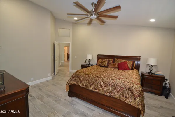 a bedroom with a bed and a ceiling fan