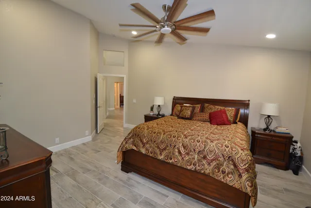 a bedroom with a bed and a ceiling fan