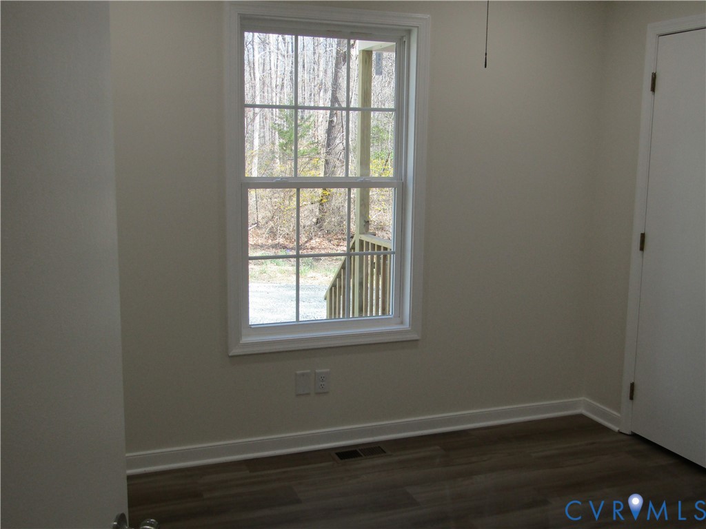 5705 Community House Road Columbia, VA 23038 - Photo 11 of 23 an empty room with wooden floor and windows