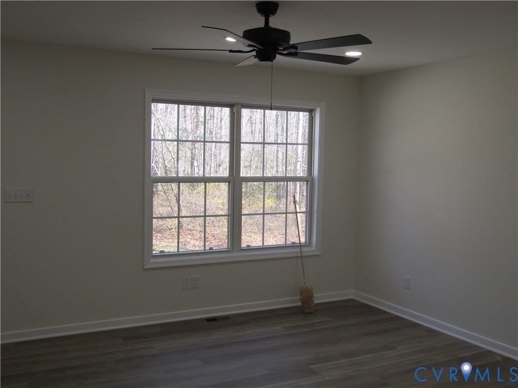 5705 Community House Road Columbia, VA 23038 - Photo 14 of 23 an empty room with wooden floor chandelier fan and windows