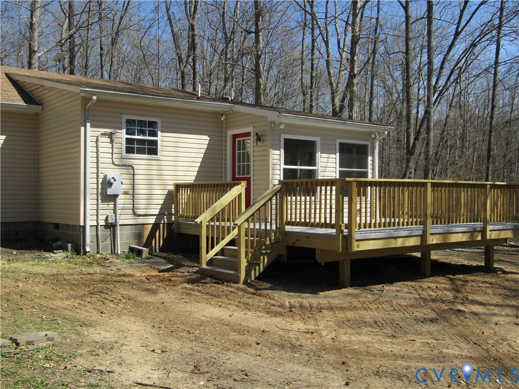 5705 Community House Road Columbia, VA 23038 - Photo 2 of 23 a view of a house with a wooden deck and a backyard