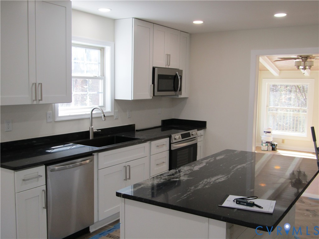 5705 Community House Road Columbia, VA 23038 - Photo 7 of 23 a kitchen with granite countertop a sink a stove and cabinets