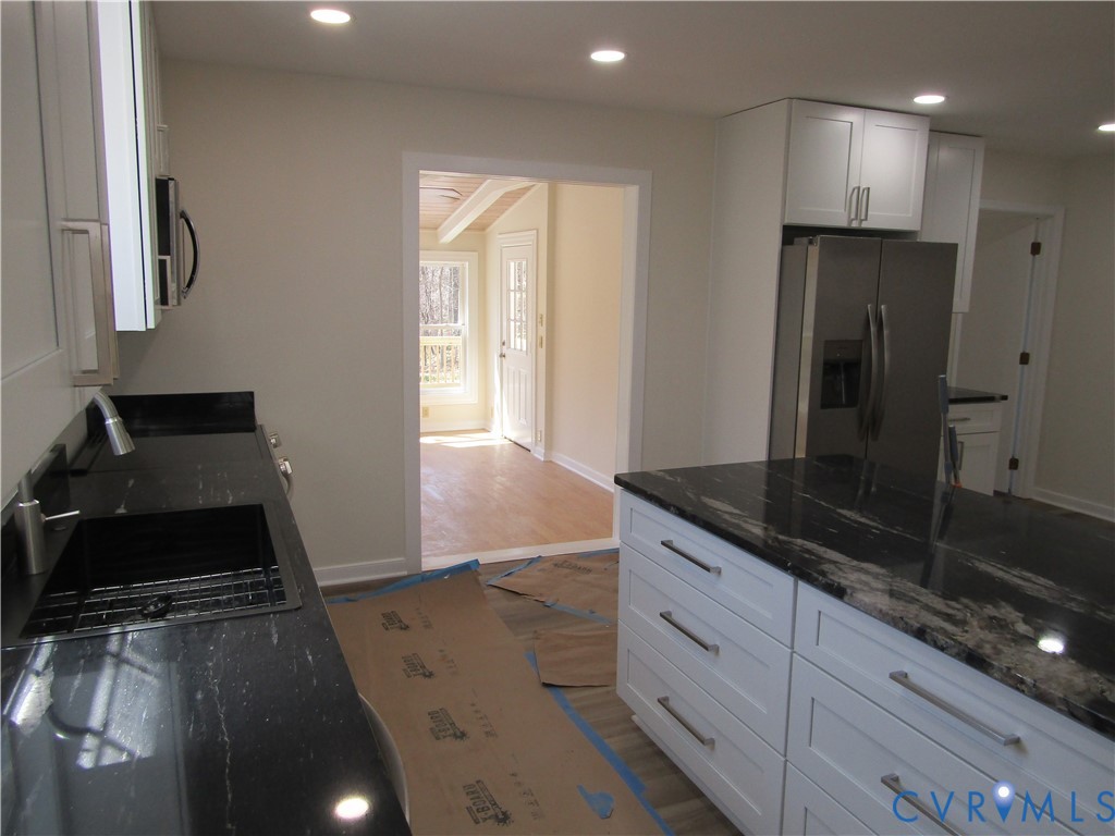 5705 Community House Road Columbia, VA 23038 - Photo 8 of 23 a kitchen with granite countertop a sink and a stove top oven