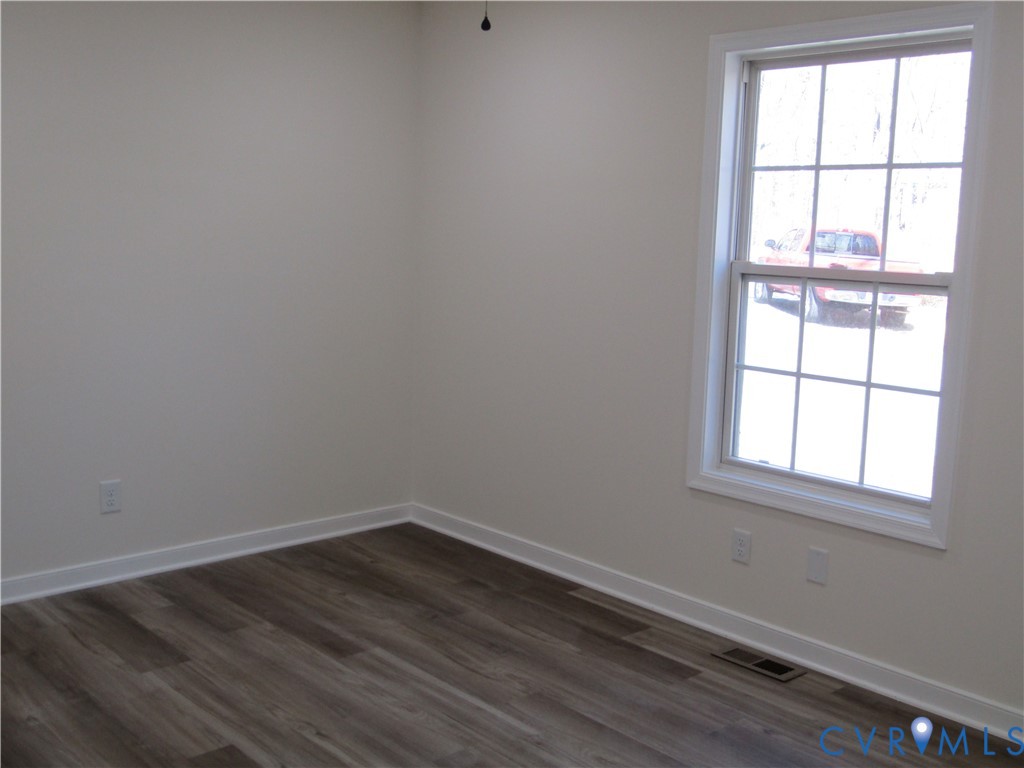 5705 Community House Road Columbia, VA 23038 - Photo 10 of 23 an empty room with wooden floor and windows