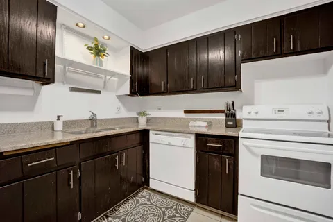 a kitchen with granite countertop stainless steel appliances a sink stove and refrigerator