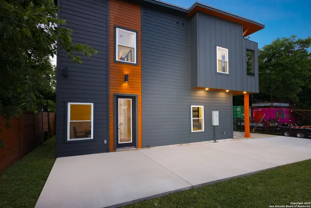 a view of a house with backyard and a tree