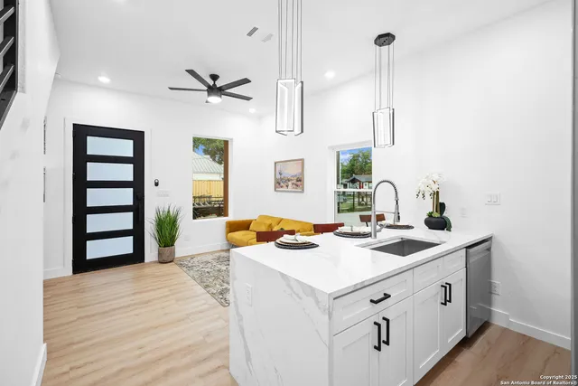 a kitchen that has a sink a stove and a wooden floor