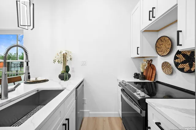 a kitchen with a sink and a stove with a microwave