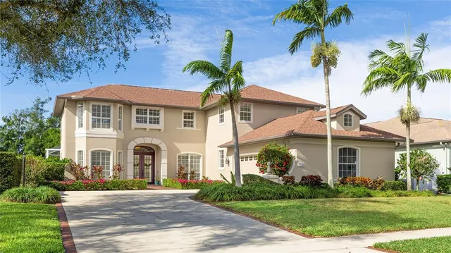 a view of a white house with a big yard and potted plants