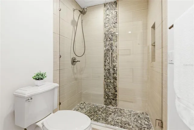 an empty room with windows and chandelier fan