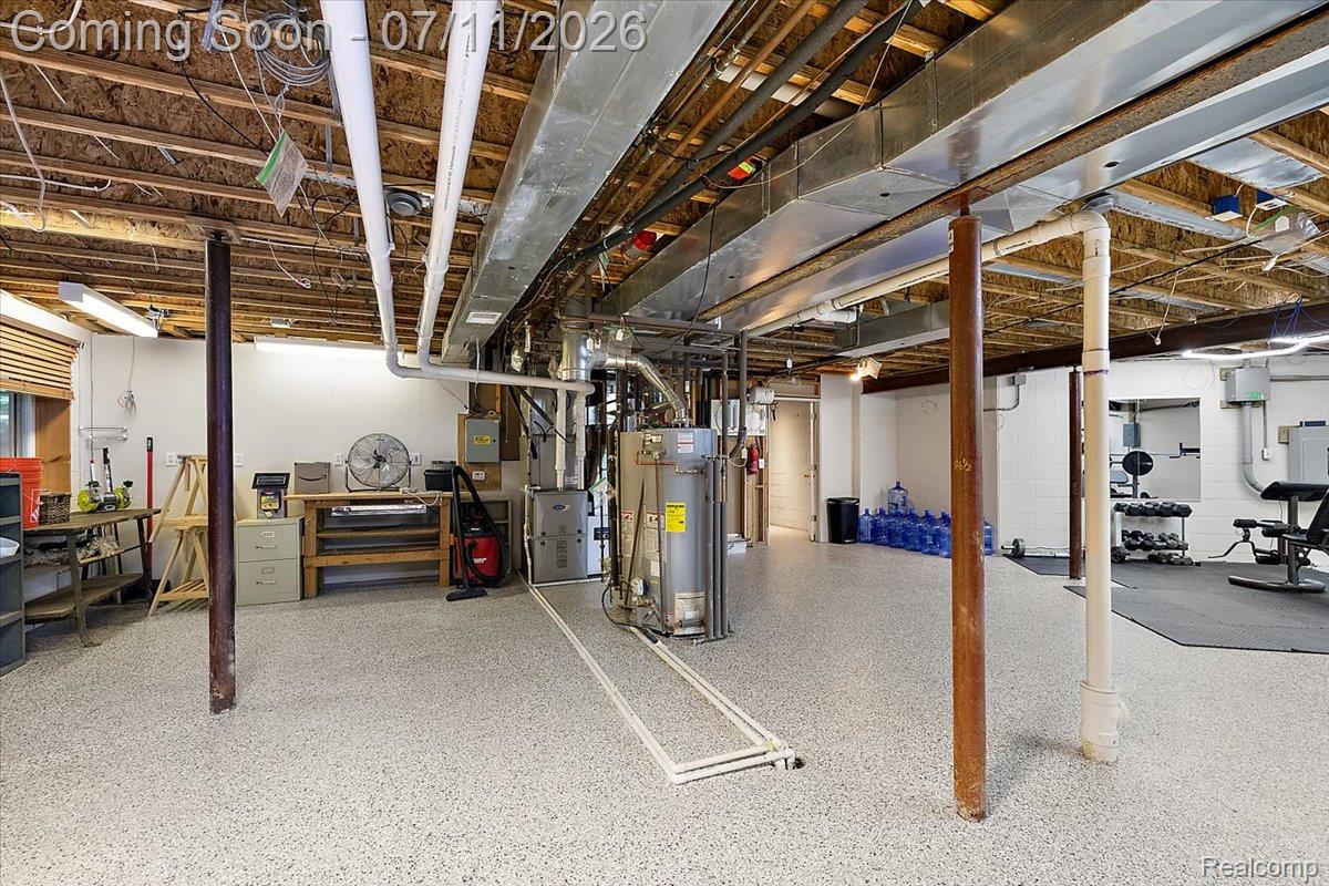 4219 Gardner Road Metamora, MI 48455 - Photo 60 of 87 Spacious utility area featuring exposed joist ceilings, comprehensive ductwork, a water heater, and an epoxy-coated concrete floor