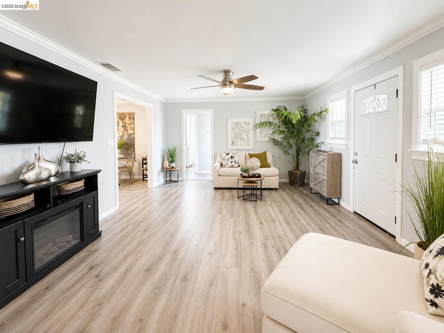 2191 East Cypress Road Oakley, CA 94561 - Photo 6 of 48 Spacious living area featuring light wood-finish flooring, light gray walls, white crown molding, and a ceiling fan