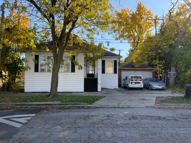 a view of a house with a tree in front of it