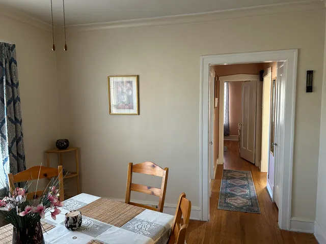 a view of a hallway with furniture and wooden floor