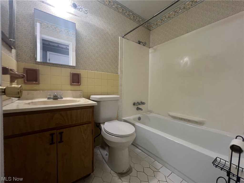 5651 Broadview Road, Unit C 07 Cleveland, OH 44134 - Photo 13 of 15 Full bathroom with tile walls, toilet, tile flooring, oversized vanity, and shower / tub combination