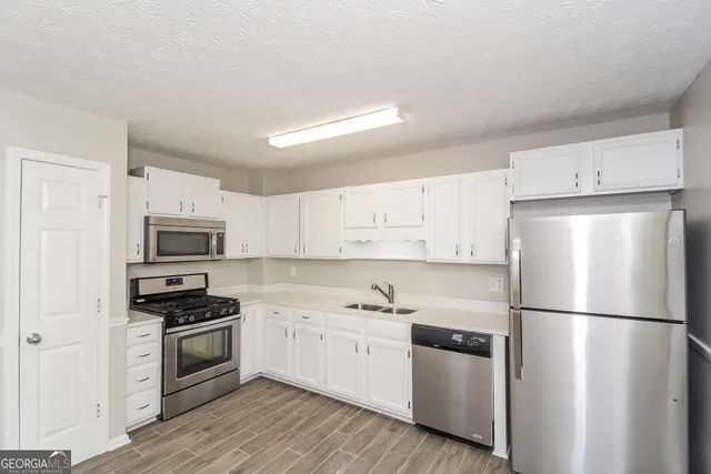 a kitchen with a refrigerator stove and white cabinets