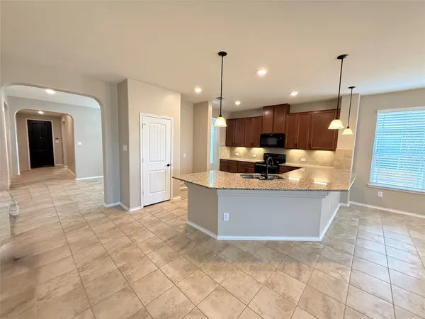 a view of kitchen with granite countertop living room and window