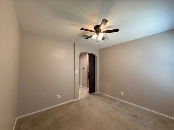 an empty room with a fan and a fan