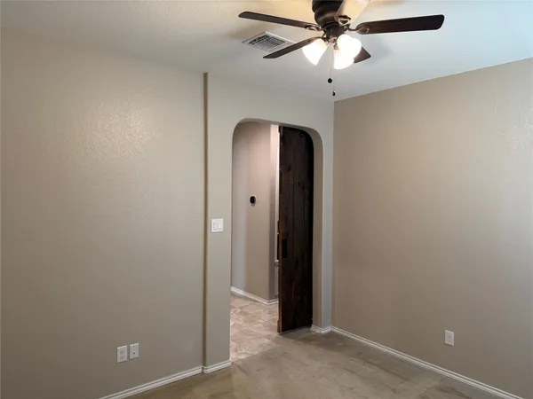 an empty room with a chandelier fan and a chandelier fan