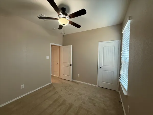 an empty room with closet and fan