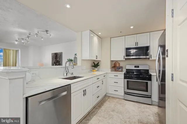 a kitchen with sink a microwave and cabinets