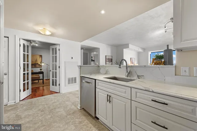 a spacious bathroom with a granite countertop sink and a mirror