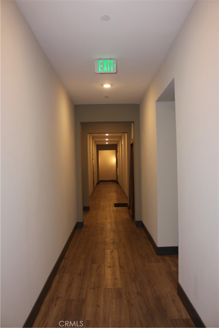 1661 Spring Street, Unit 444 Davis, CA 95616 - Photo 14 of 16 a view of a hallway with wooden floor and a fireplace