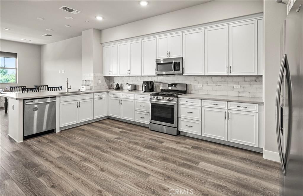 1661 Spring Street, Unit 444 Davis, CA 95616 - Photo 6 of 16 a kitchen with stainless steel appliances granite countertop a stove top oven a sink dishwasher and a refrigerator