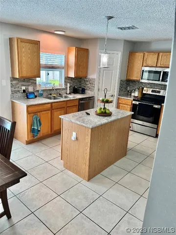 a large kitchen with stainless steel appliances granite countertop a stove a sink and a microwave