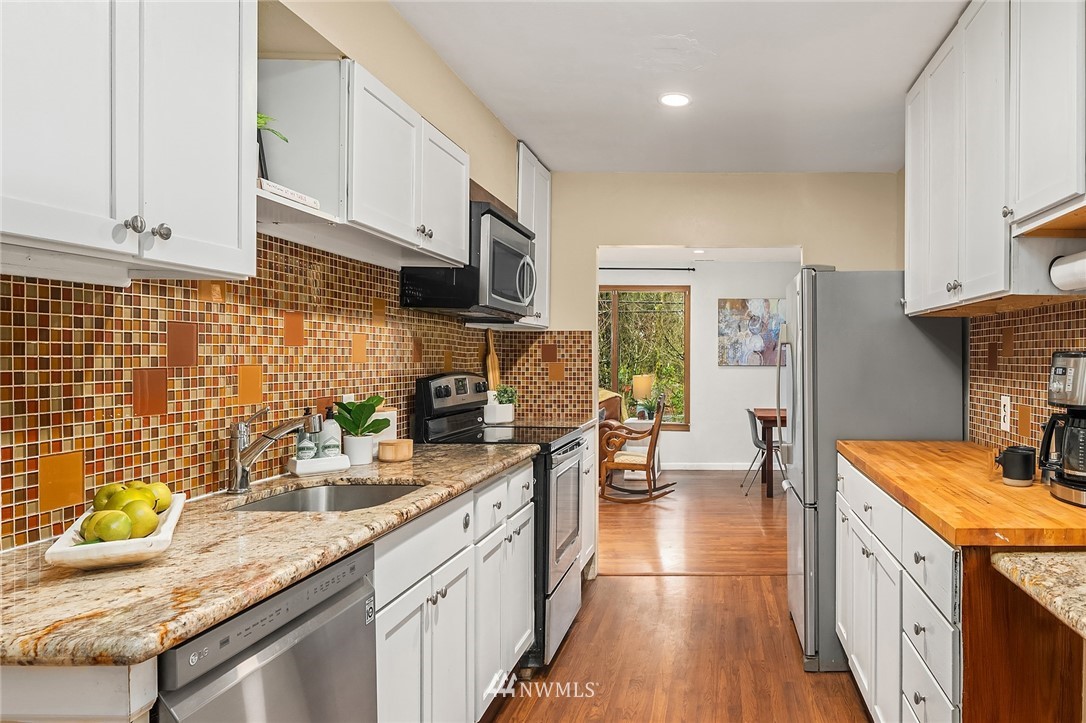 19607 Southeast 149th Street Renton, WA 98059 - Photo 16 of 34 a kitchen with granite countertop a sink a stove and wooden cabinets