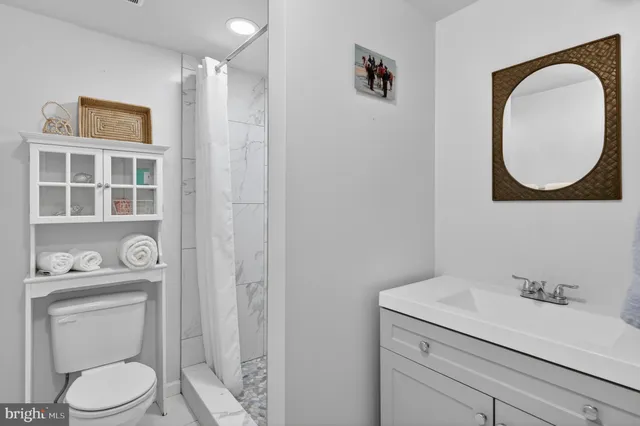 a bathroom with a sink a toilet and a mirror