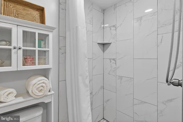 a bathroom with a granite countertop shower and a window