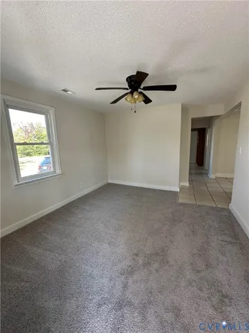 an empty room with windows and a ceiling fan
