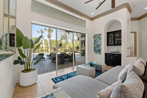 a living room with furniture a flat screen tv and a large window