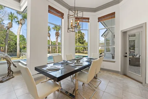 a view of a dining room with furniture large windows and wooden floor