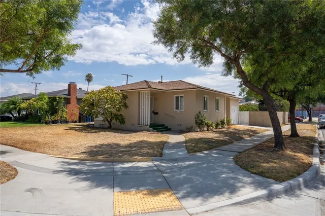 a view of a house with a yard and large tree