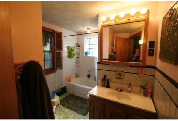 a bathroom with a sink and mirror with toilet