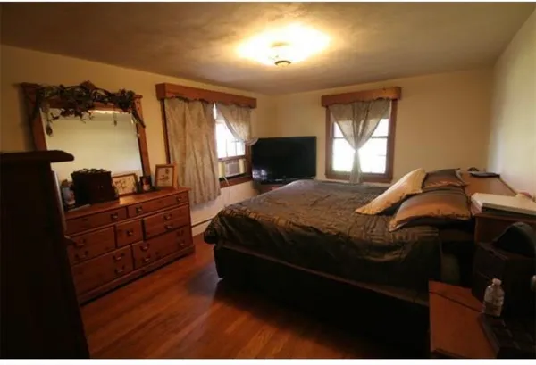 a bedroom with a bed and dresser with mirror
