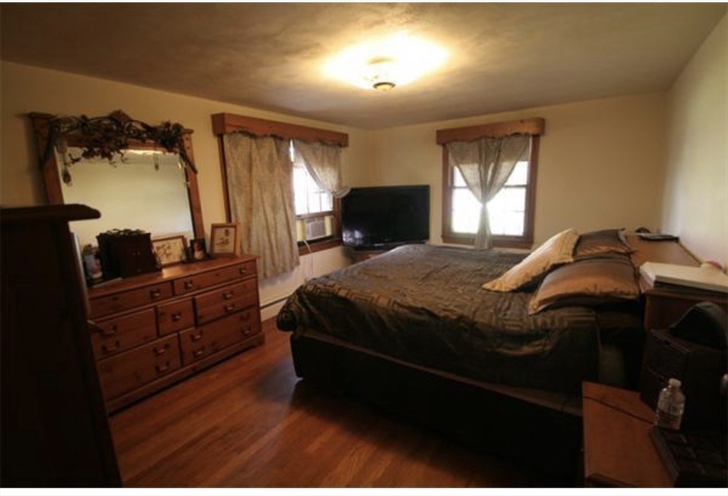 211 Russell Street Hadley, MA 01035 - Photo 13 of 20 a bedroom with a bed and dresser with mirror