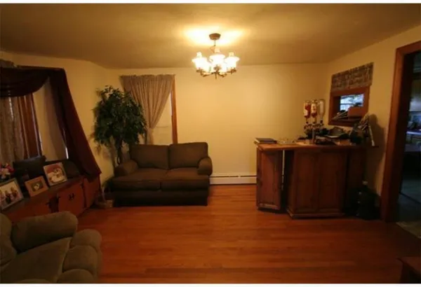 a living room with furniture a chandelier and a flat screen tv