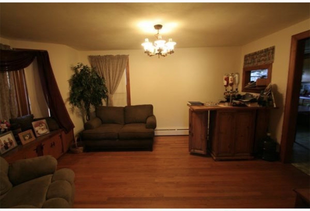 211 Russell Street Hadley, MA 01035 - Photo 3 of 20 a living room with furniture a chandelier and a flat screen tv