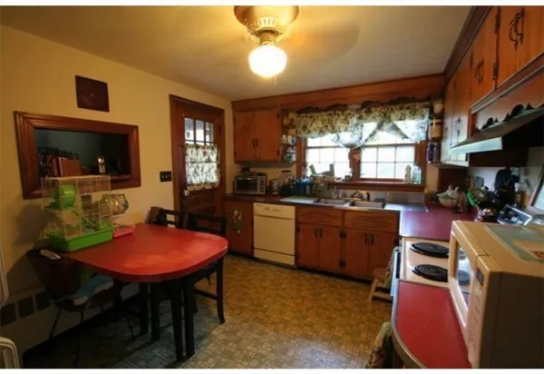 a kitchen with a table chairs sink and cabinets