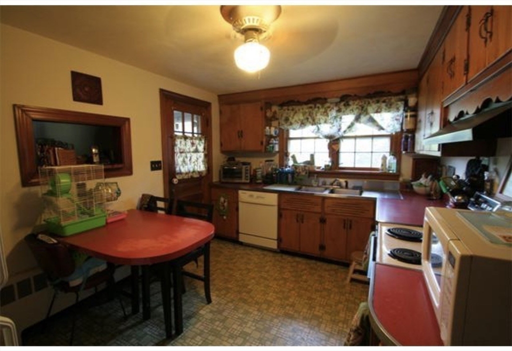 211 Russell Street Hadley, MA 01035 - Photo 9 of 23 a kitchen with a table chairs sink and cabinets