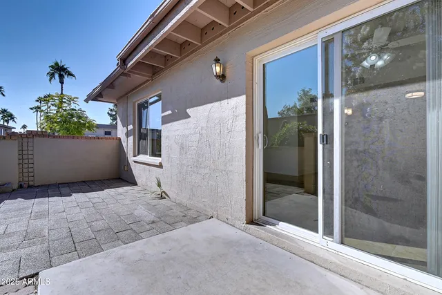 a view of a house with a potted plant and floor to ceiling window