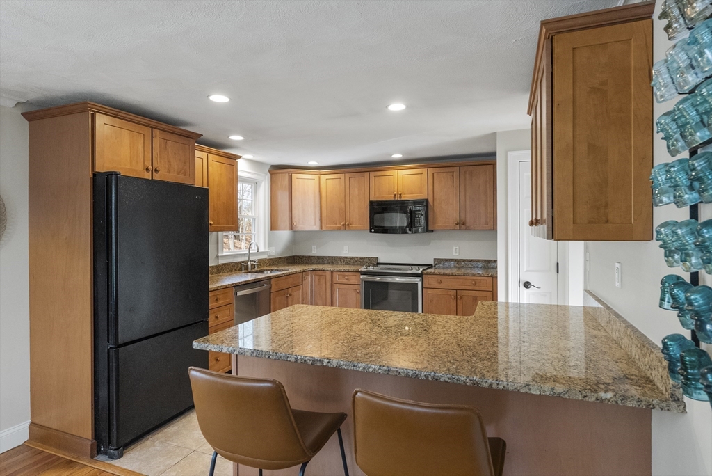 30 Pawtuxet Road Plymouth, MA 02360 - Photo 22 of 42 a kitchen with stainless steel appliances granite countertop a refrigerator a stove and a sink with wooden cabinets