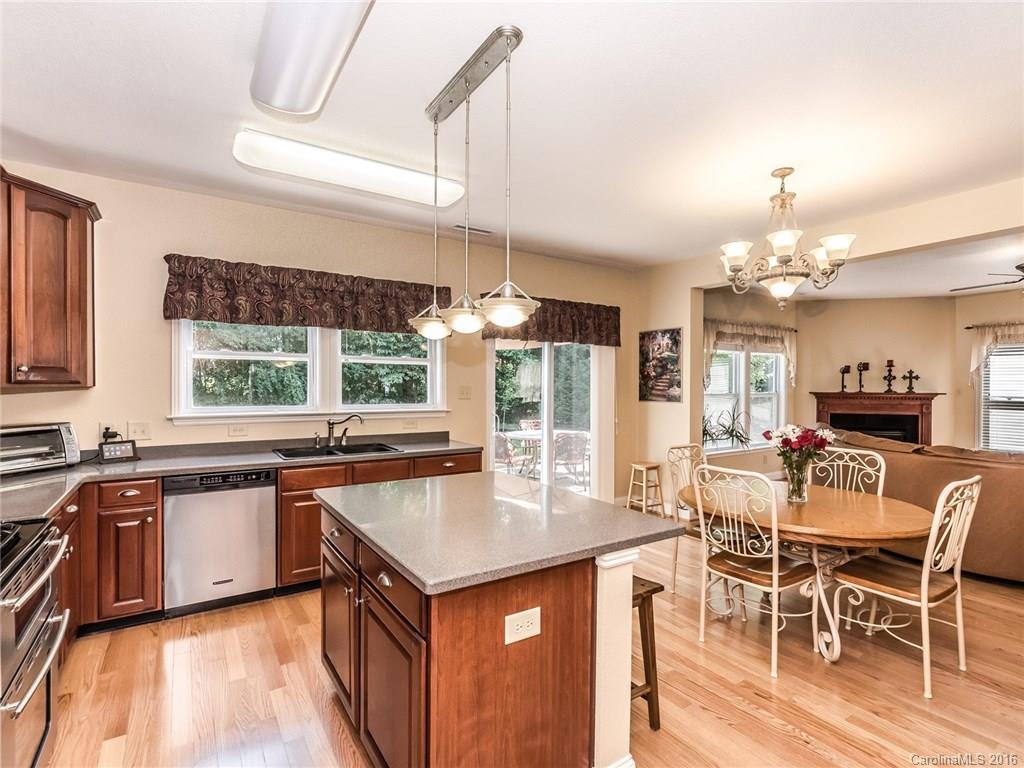 2074 Durand Road, Unit 18 Fort Mill, SC 29715 - Photo 11 of 24 a kitchen with a stove a sink a dining table and chairs