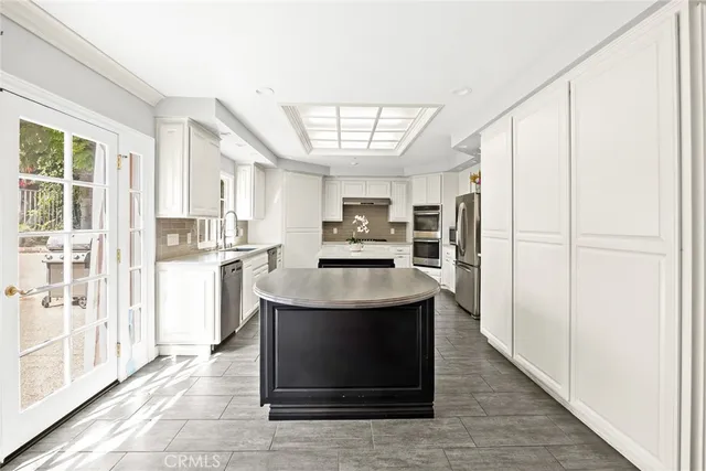 a spacious bedroom with a bed a dresser and mirror